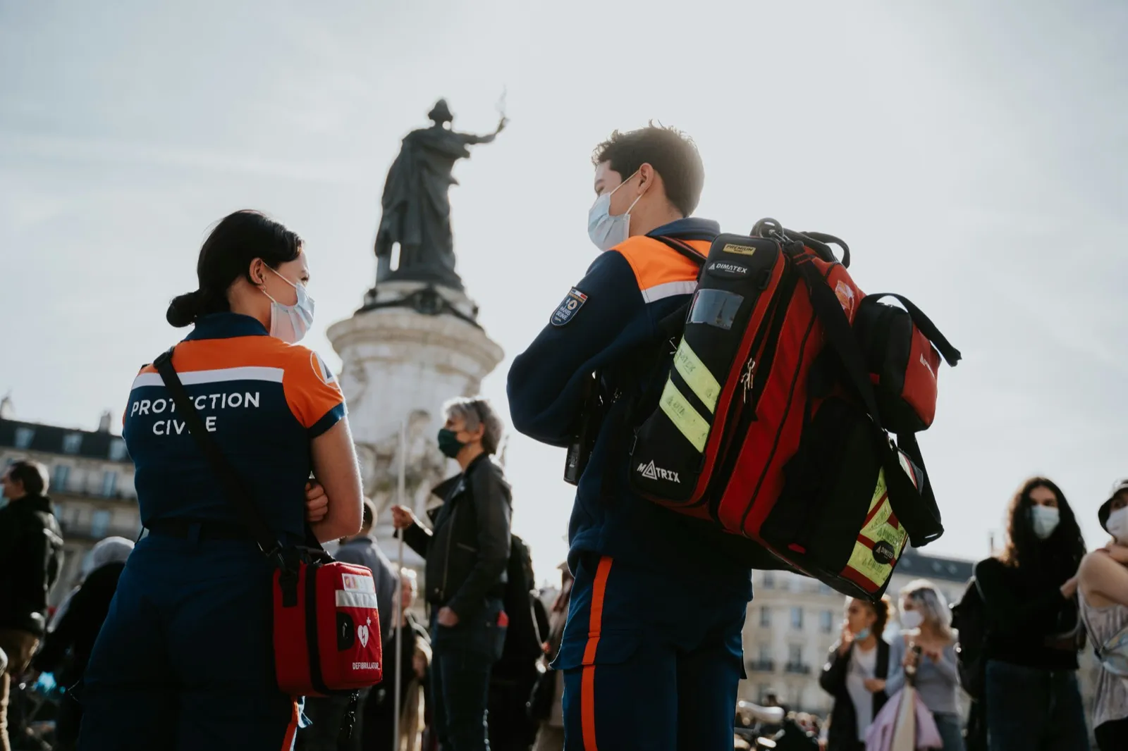 Due soccorritori in divisa ad alta visibilità accanto ai propri zaini di intervento.